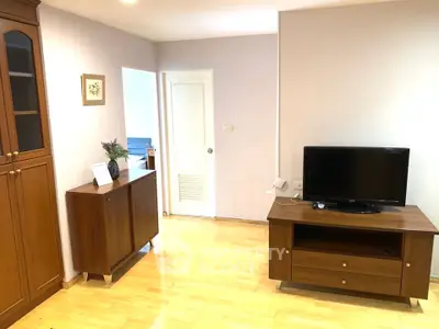 Spacious living room with wooden furniture and modern TV setup