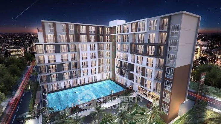 Luxurious modern apartment complex with illuminated pool and city skyline view at night.