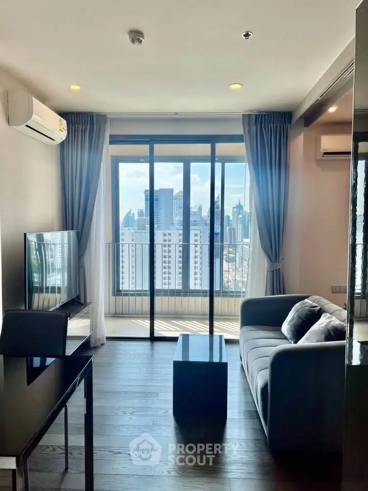 Modern living room with city view, featuring sleek furniture and large windows for natural light.