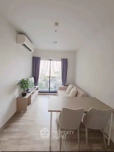 Modern living room with balcony, featuring sleek furniture and natural light, perfect for urban living.