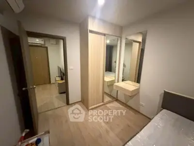 Modern bedroom with mirrored wardrobe and wooden flooring in a cozy apartment.