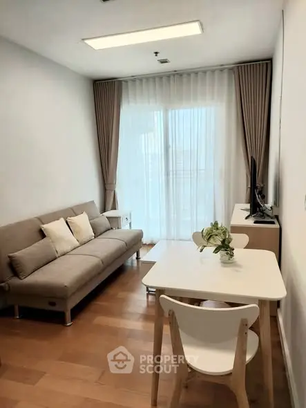 Modern living room with cozy sofa and dining area, featuring floor-to-ceiling windows and elegant curtains.