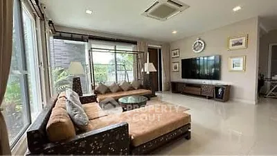 Spacious living room with modern decor and large windows offering natural light