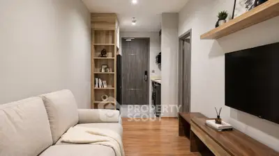 Modern living room with cozy sofa, wooden flooring, and stylish shelving in a contemporary apartment.