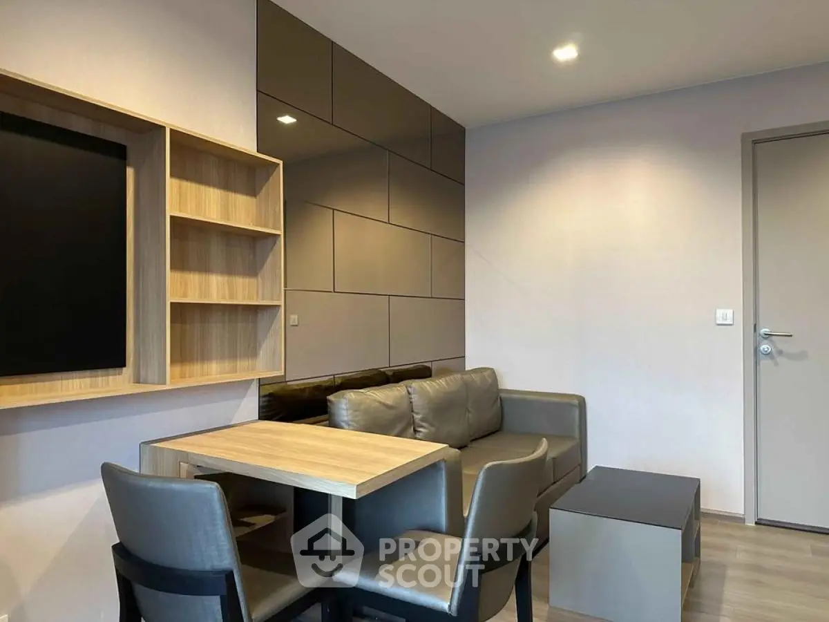 Modern living room with sleek furniture and wall-mounted TV in a stylish apartment.