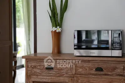 Charming kitchen corner with rustic wooden cabinet and modern microwave.