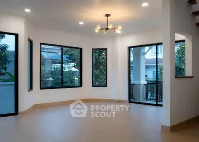 Spacious corner unit with large windows and modern lighting in a bright living room.