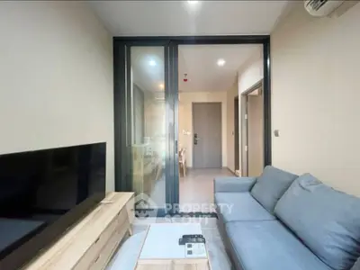 Modern living room with sleek furniture and large TV, perfect for relaxation and entertainment.