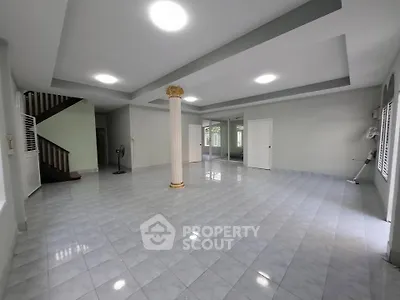 Spacious open-plan living area with elegant column and tiled flooring