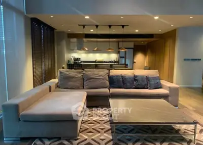 Spacious modern living room with stylish furniture and open kitchen layout, perfect for entertaining.