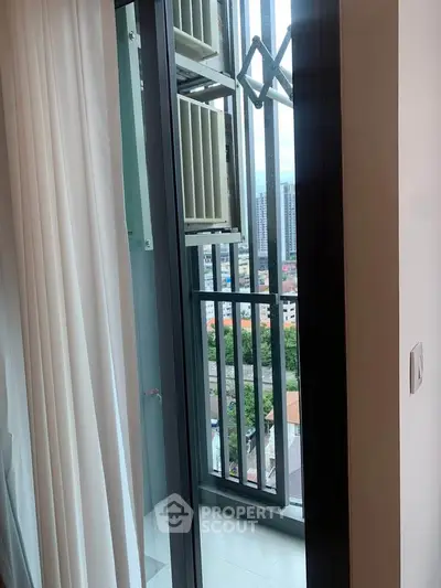 Modern apartment balcony with city view and glass door