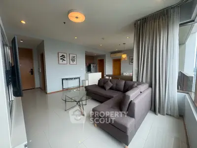 Modern living room with sleek furniture and large windows offering natural light.