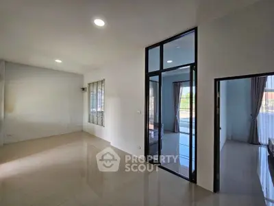Spacious modern living room with large windows and sleek tile flooring, perfect for natural light and open living.