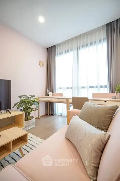 Chic and cozy living room with soft pink decor and natural light