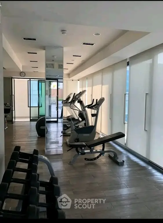 Modern gym with state-of-the-art equipment and sleek design in a luxury residential building.