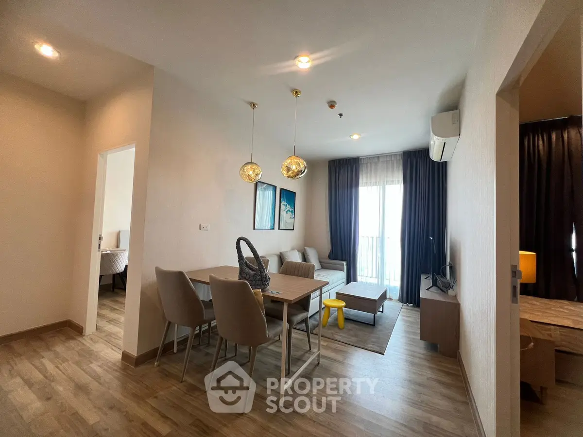 Modern living room with dining area, stylish lighting, and cozy decor