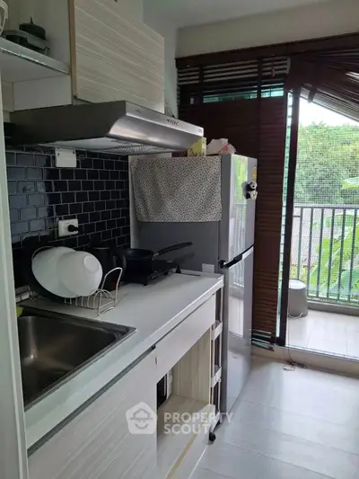 Modern kitchen with sleek appliances and balcony view, perfect for urban living.