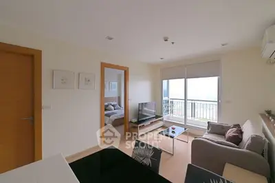 Modern living room with balcony view and cozy furnishings in a stylish apartment.