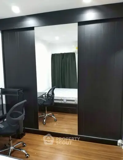 Modern bedroom with mirrored wardrobe and sleek office chair