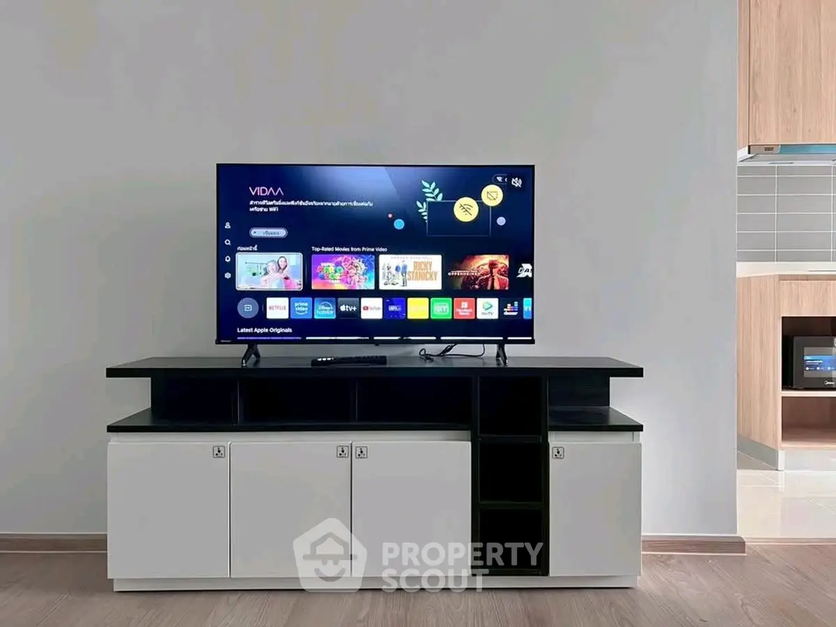Modern living room with sleek TV stand and flat-screen TV, showcasing minimalist design and stylish decor.