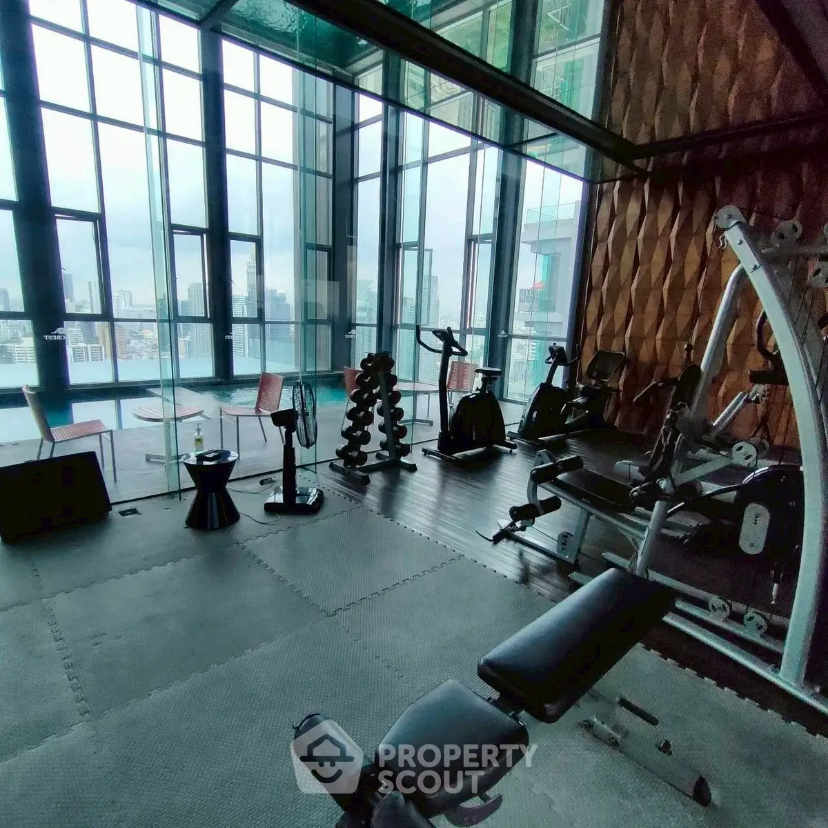 Luxurious high-rise gym with panoramic city views and modern fitness equipment.