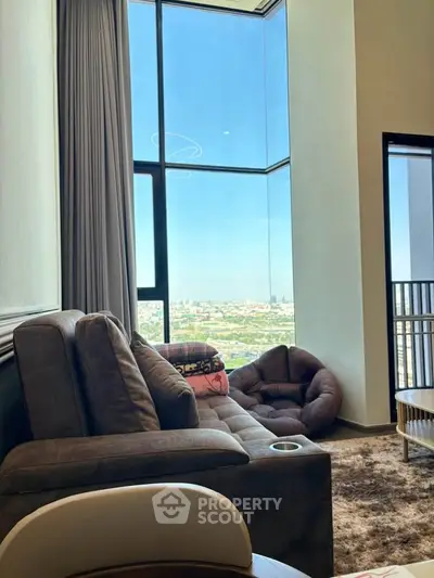 Luxurious living room with panoramic city view and plush seating in a high-rise apartment.