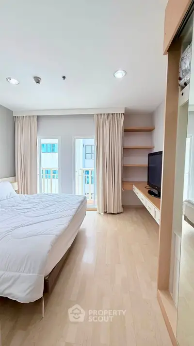 Bright and airy bedroom with modern furnishings and large windows in a stylish apartment.
