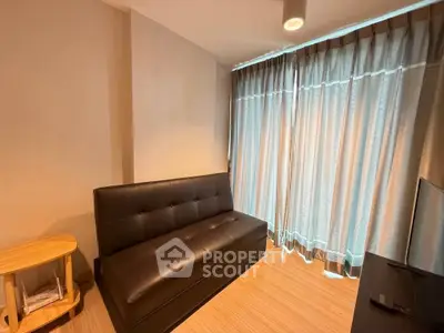 Cozy living room with modern sofa and floor-to-ceiling curtains, perfect for relaxation.