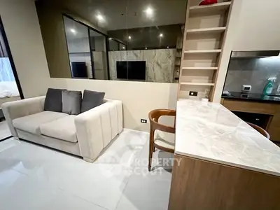 Modern living room with cozy sofa and sleek kitchen counter in stylish apartment.