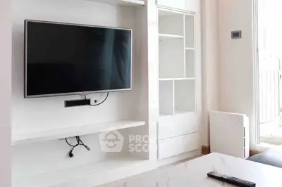 Modern living room with sleek TV setup and stylish white shelving.