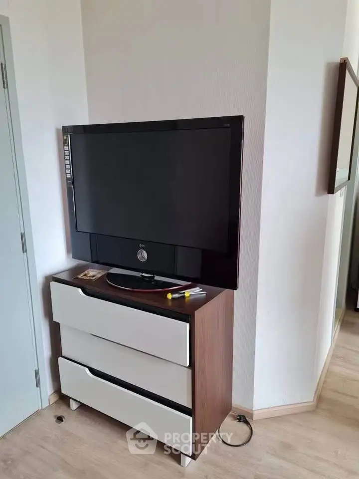 Modern apartment corner with TV on sleek dresser, showcasing minimalist design.