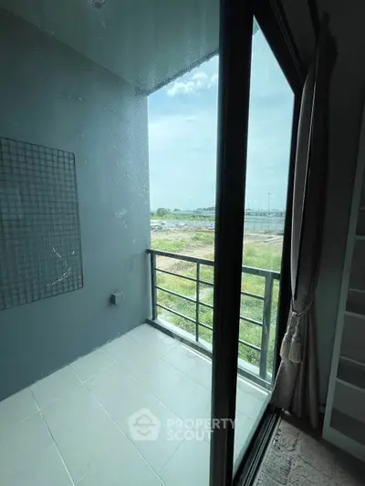 Modern balcony with glass doors and scenic view, perfect for relaxation.