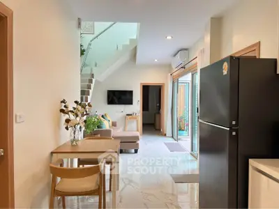 Modern open-plan living area with sleek kitchen and stylish staircase