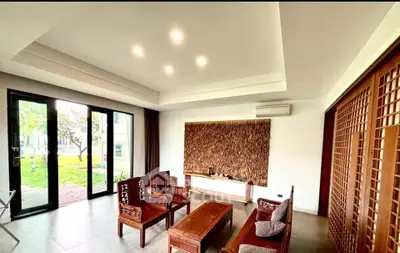 Spacious living room with elegant wooden furniture and garden view, perfect for relaxation and entertaining.