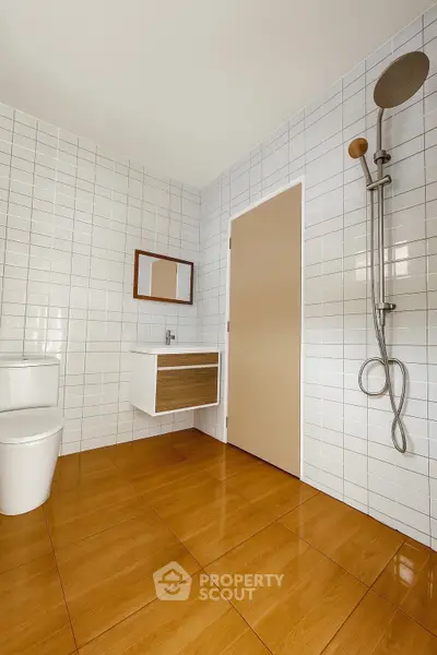 Modern minimalist bathroom with sleek fixtures and wooden flooring