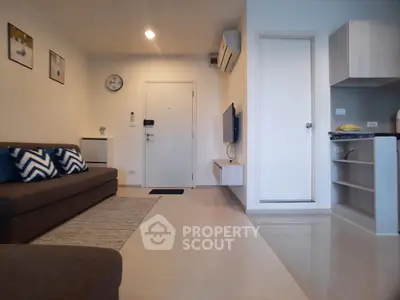 Modern living room with sleek furniture and open kitchen layout in a stylish apartment.