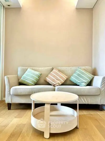 Modern living room with stylish sofa and round coffee table on wooden floor.