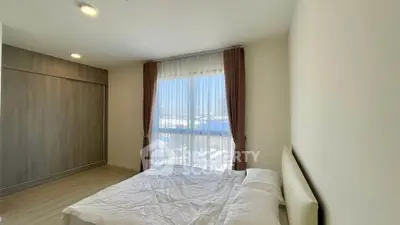 Bright and cozy bedroom with large window and modern furnishings in a stylish apartment.