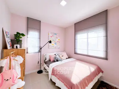 Charming bedroom with pink accents and natural light, perfect for cozy living.