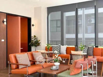 Stylish modern living room with vibrant orange seating and large windows