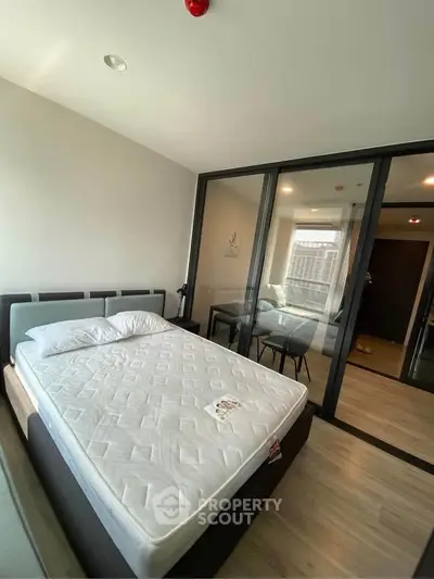 Modern bedroom with glass partition and sleek furnishings