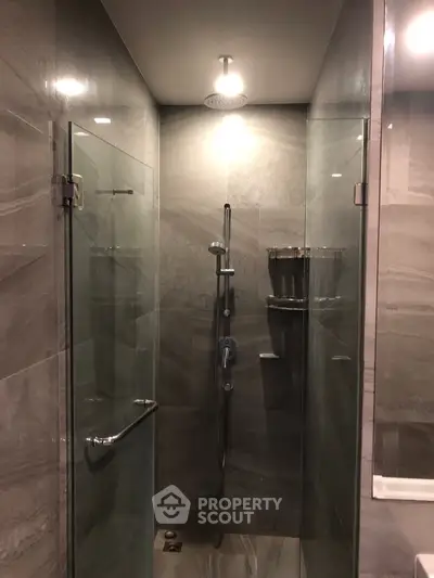 Modern bathroom with sleek glass shower enclosure and elegant tile design.