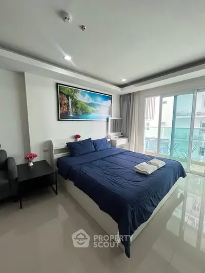 Modern bedroom with balcony access and stylish decor in a bright apartment.