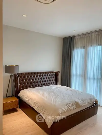 Luxurious bedroom with elegant leather bed and floor-to-ceiling windows