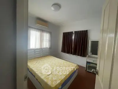 Cozy bedroom with natural light and air conditioning, featuring a comfortable bed and elegant curtains.