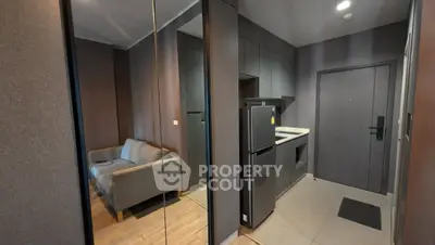 Modern apartment entrance with sleek kitchen and cozy living area