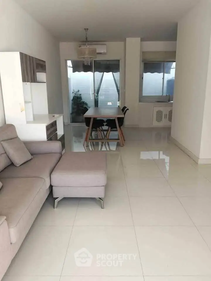 Spacious modern living room with sleek furniture and large windows offering natural light.