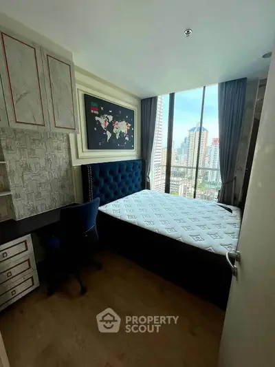 Modern bedroom with city view, featuring stylish decor and large window for natural light.