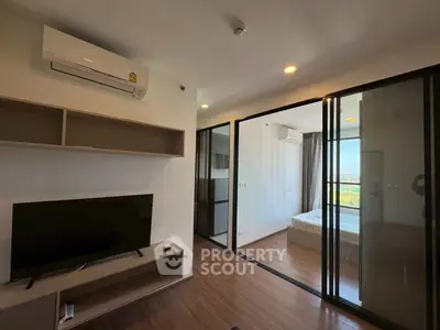 Modern apartment interior with living room and bedroom, featuring sleek design and natural light.