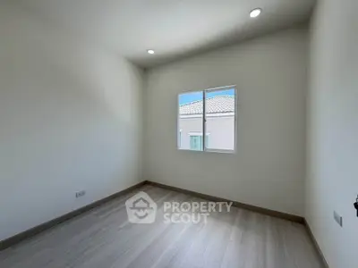 Bright empty room with wooden flooring and window view in modern home
